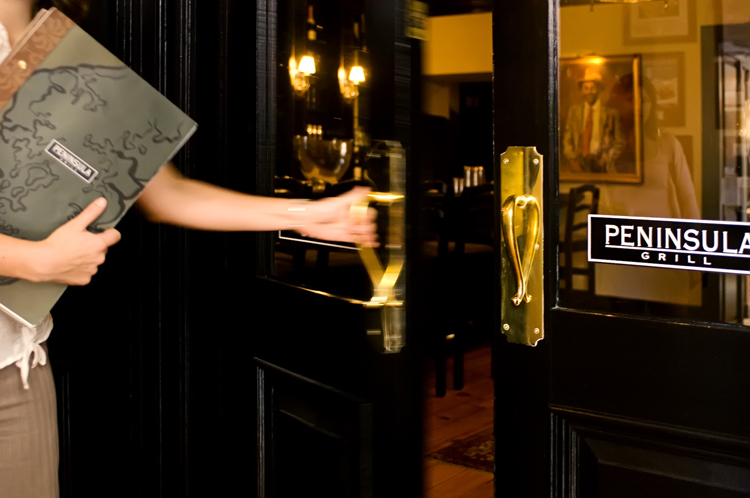 The gleaming black and gold doorway to Peninsula Grill, the iconic Charleston restaurant.