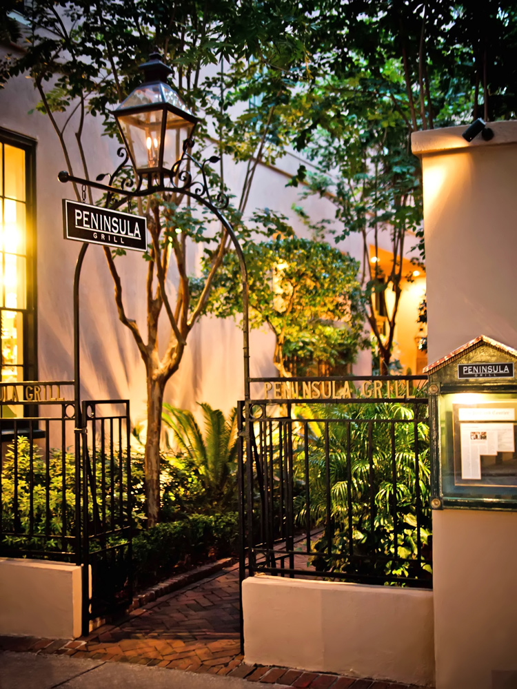 The garden entry to Peninsula Grill in Charleston SC is lit by carriage lanterns.